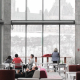 People resting on chairs within an open indoor space reminiscent of a library