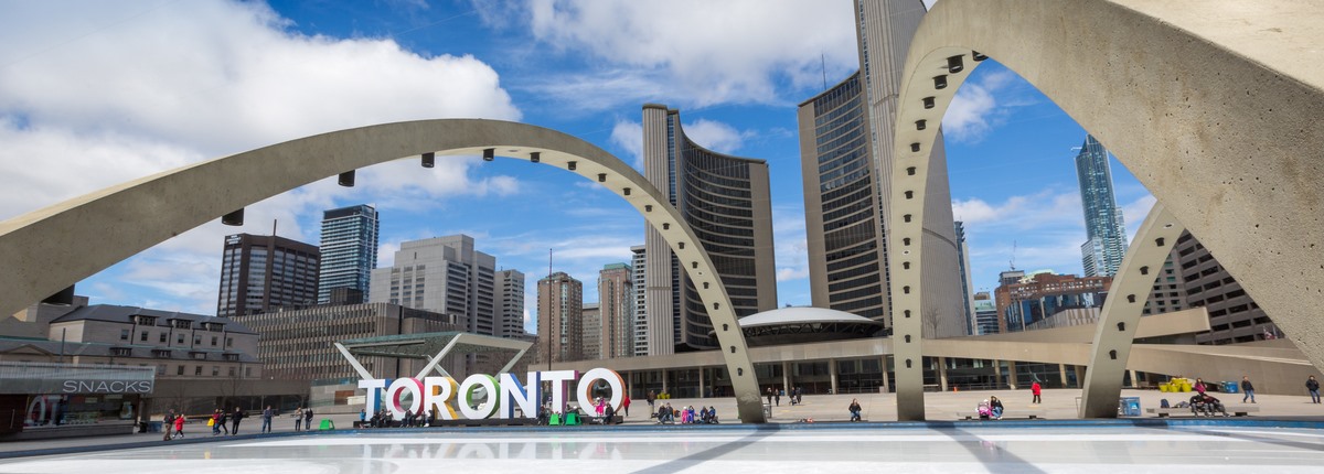 Concrete arches loom over a plaza containing public art spelling out the word Toronto