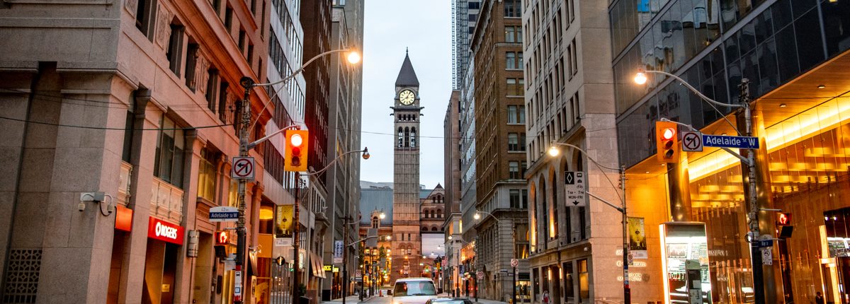 A bell tower stands at the end of a city centre street in Toronto, Canada